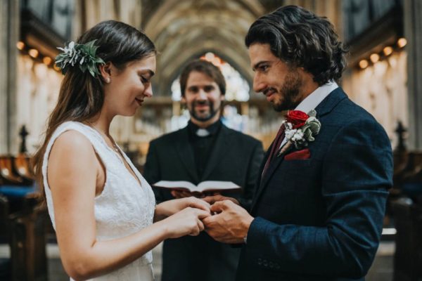 Bride and groom holding hands in front of a minister.