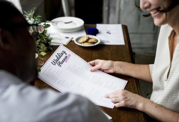 A woman holding a wedding planner checklist.