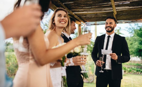 Wedding party standing together listening to a toast.