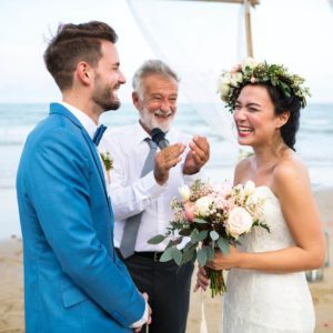 Bride and groom getting married on a beach.