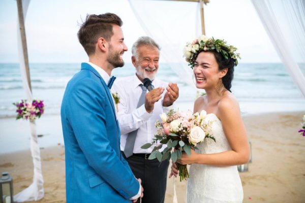 Bride and groom getting married on a beach.